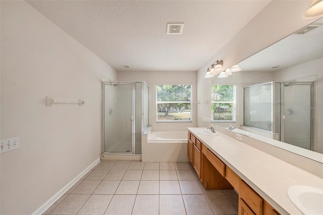 bathroom featuring double vanity, a stall shower, tile patterned floors, a garden tub, and a textured ceiling