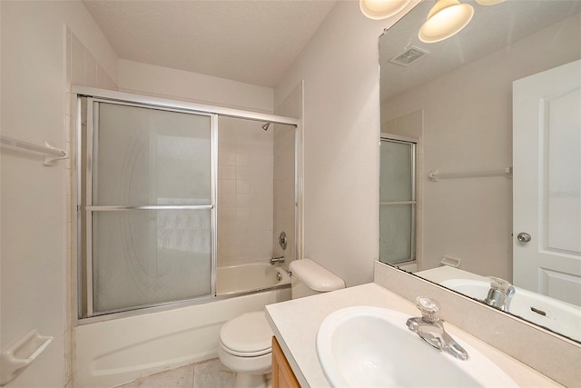 bathroom featuring toilet, vanity, shower / bath combination with glass door, and tile patterned floors