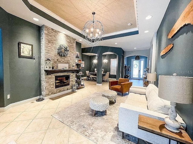 21513 Belvedere Ln, Estero, FL 33928 - tiled living room featuring a raised ceiling, arched walkways, a chandelier, a fireplace, and recessed lighting