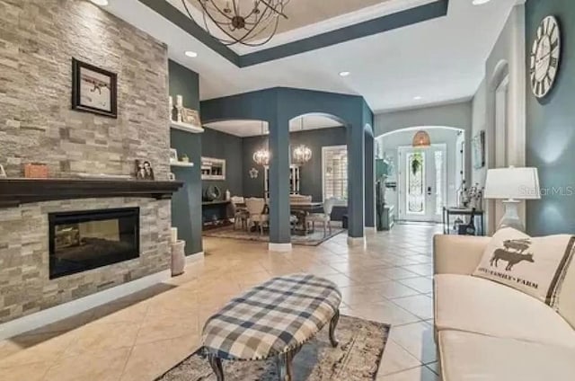 21513 Belvedere Ln, Estero, FL 33928 - living area with arched walkways, a chandelier, light tile patterned floors, recessed lighting, and a stone fireplace