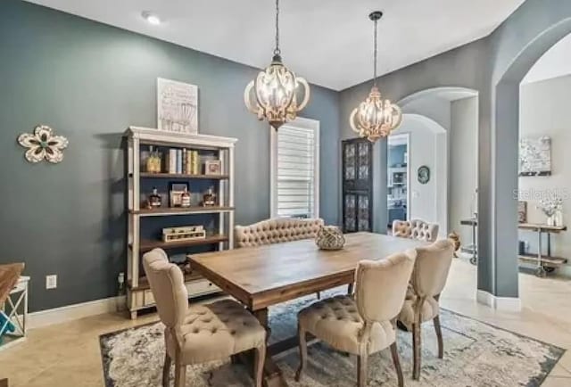 21513 Belvedere Ln, Estero, FL 33928 - dining space featuring arched walkways, a chandelier, and baseboards