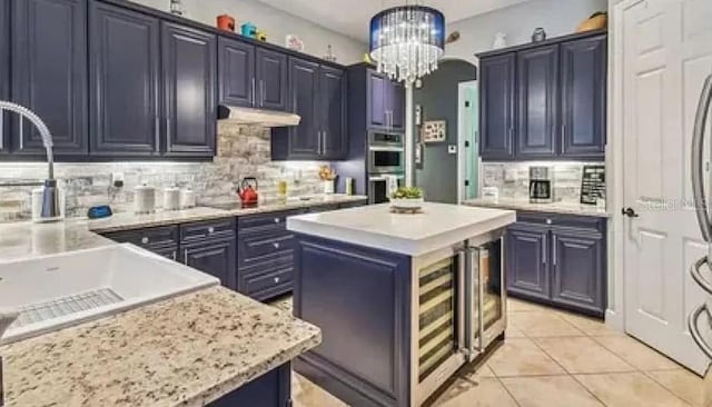 21513 Belvedere Ln, Estero, FL 33928 - kitchen featuring a sink, backsplash, stainless steel double oven, a kitchen island, and blue cabinets