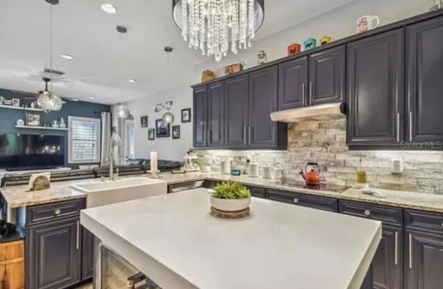 21513 Belvedere Ln, Estero, FL 33928 - kitchen featuring a kitchen island, under cabinet range hood, a peninsula, tasteful backsplash, and recessed lighting