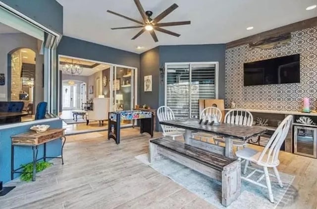 21513 Belvedere Ln, Estero, FL 33928 - dining area with wood finished floors, ceiling fan, arched walkways, a chandelier, and wallpapered walls