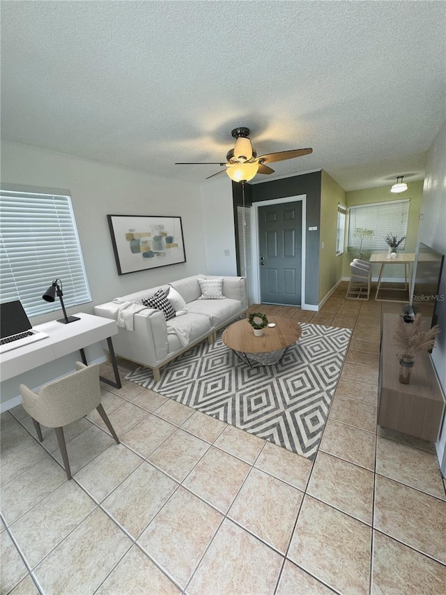 living room with tile patterned floors, a ceiling fan, a textured ceiling, and an office area