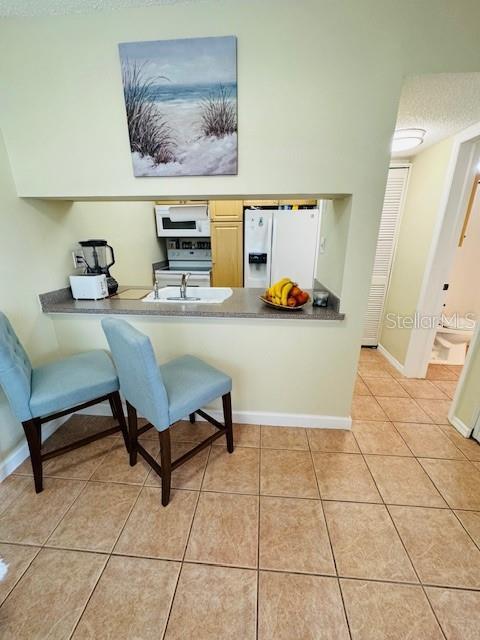 sitting room featuring light tile patterned flooring and baseboards