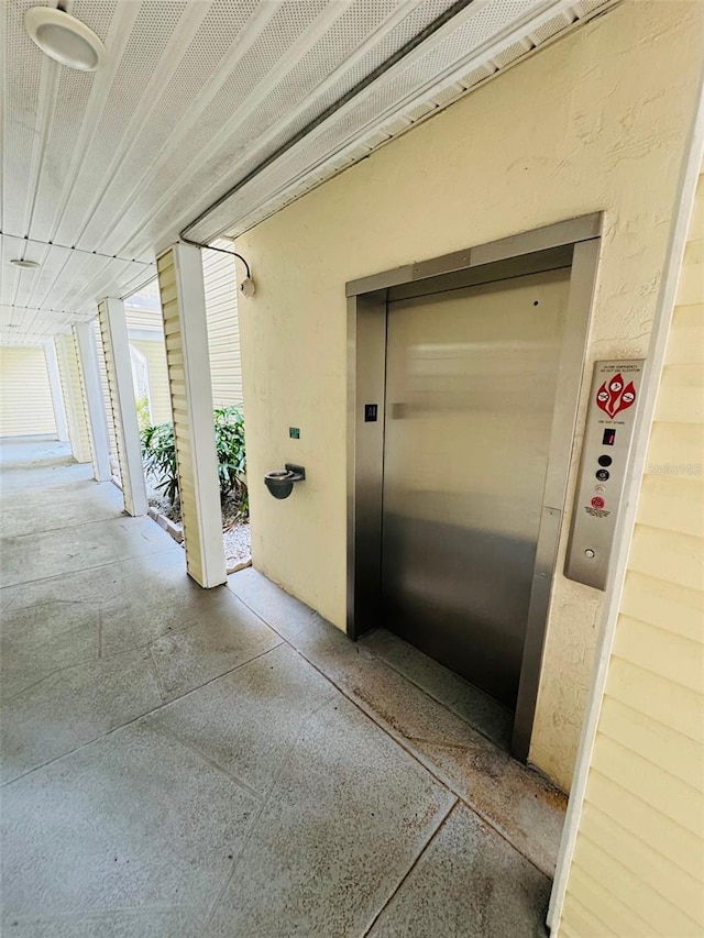 property entrance featuring elevator and stucco siding