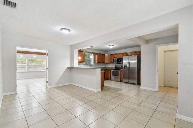 5010 8th Ave N, Saint Petersburg, FL 33710 - kitchen with stainless steel appliances, plenty of natural light, a peninsula, and light tile patterned flooring