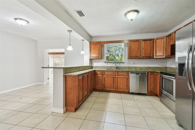 5010 8th Ave N, Saint Petersburg, FL 33710 - kitchen featuring stainless steel appliances, a peninsula, dark stone countertops, light tile patterned flooring, and a sink