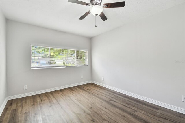 5010 8th Ave N, Saint Petersburg, FL 33710 - empty room with dark wood-style flooring, baseboards, and ceiling fan