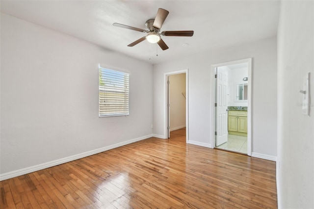 5010 8th Ave N, Saint Petersburg, FL 33710 - unfurnished bedroom with a spacious closet, light wood-type flooring, baseboards, ensuite bathroom, and a closet