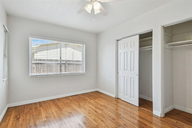 5010 8th Ave N, Saint Petersburg, FL 33710 - unfurnished bedroom featuring wood finished floors, baseboards, ceiling fan, and multiple closets
