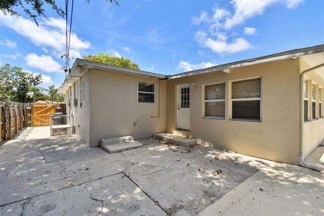 5010 8th Ave N, Saint Petersburg, FL 33710 - back of house featuring stucco siding, a patio, and a gate