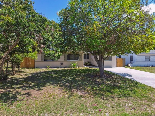 5010 8th Ave N, Saint Petersburg, FL 33710 - obstructed view of property with concrete driveway, stucco siding, and a front yard