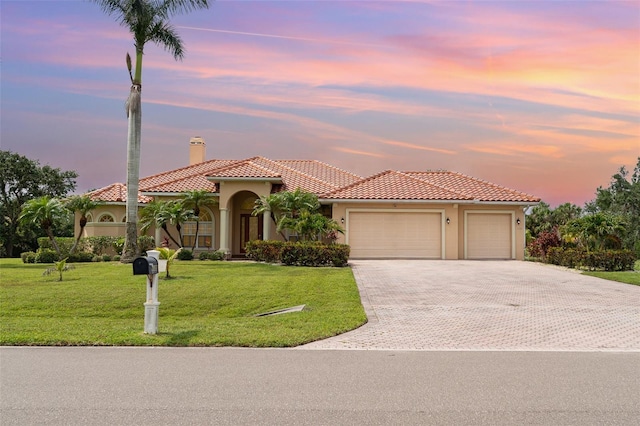 6120 9th Avenue Cir NE, Bradenton, FL 34212 - mediterranean / spanish home with a tiled roof, a garage, stucco siding, a chimney, and decorative driveway