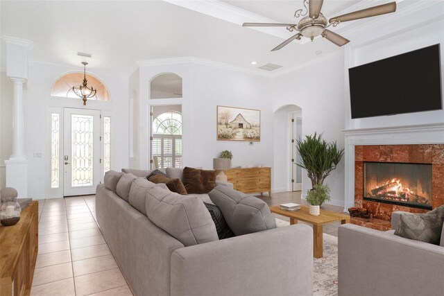 6120 9th Avenue Cir NE, Bradenton, FL 34212 - living area with arched walkways, light tile patterned floors, a ceiling fan, a premium fireplace, and crown molding