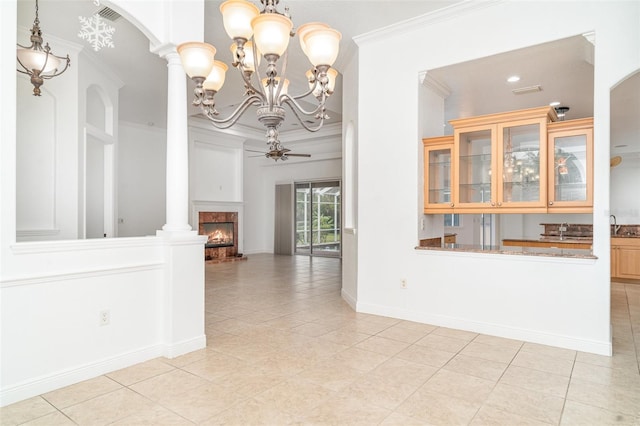 6120 9th Avenue Cir NE, Bradenton, FL 34212 - unfurnished dining area featuring crown molding, decorative columns, a chandelier, a warm lit fireplace, and light tile patterned floors