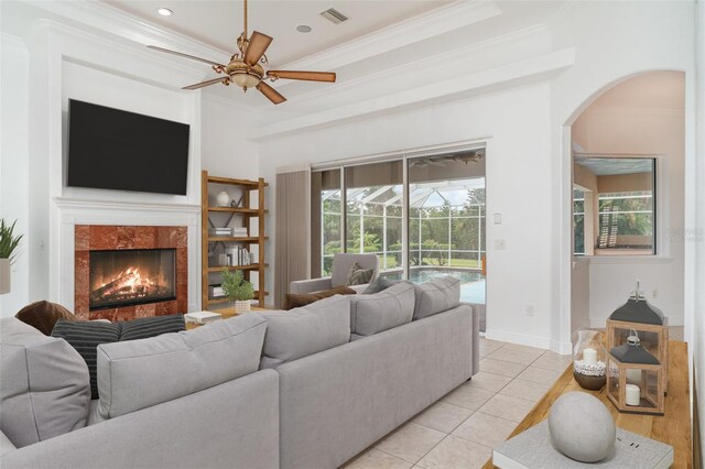 6120 9th Avenue Cir NE, Bradenton, FL 34212 - living area featuring arched walkways, crown molding, a fireplace, a ceiling fan, and light tile patterned floors