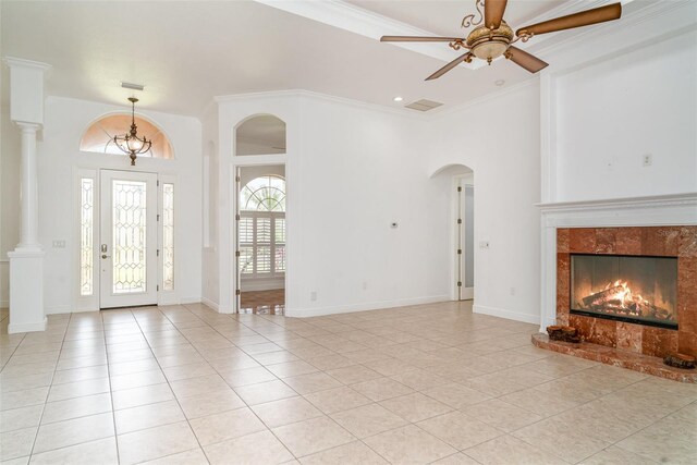 6120 9th Avenue Cir NE, Bradenton, FL 34212 - foyer featuring a ceiling fan, light tile patterned floors, arched walkways, a tiled fireplace, and crown molding