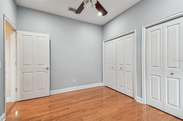 21215 Preservation Dr, Land O Lakes, FL 34639 - unfurnished bedroom featuring two closets, light wood-style floors, baseboards, and ceiling fan