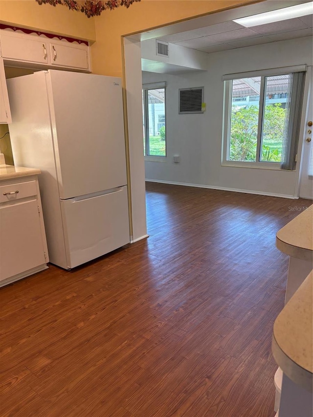 4152 56th Way N Unit 513, Kenneth City, FL 33709 - kitchen with freestanding refrigerator, dark wood-style floors, light countertops, white cabinets, and a wall mounted AC