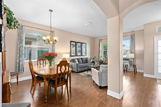 460 Tess Ct, Orlando, FL 32824 - dining space with arched walkways, wood finished floors, a textured ceiling, a chandelier, and baseboards