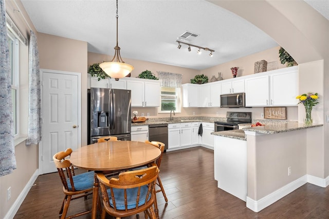 460 Tess Ct, Orlando, FL 32824 - kitchen featuring appliances with stainless steel finishes, white cabinetry, dark wood-type flooring, a textured ceiling, and track lighting