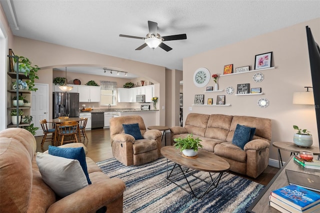 460 Tess Ct, Orlando, FL 32824 - living area with dark wood-type flooring, arched walkways, ceiling fan, and a textured ceiling