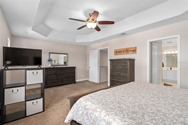 460 Tess Ct, Orlando, FL 32824 - bedroom with a tray ceiling, carpet, baseboards, ceiling fan, and connected bathroom
