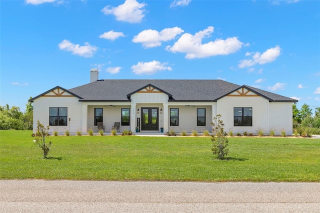 modern farmhouse with french doors, a chimney, a front yard, and a shingled roof