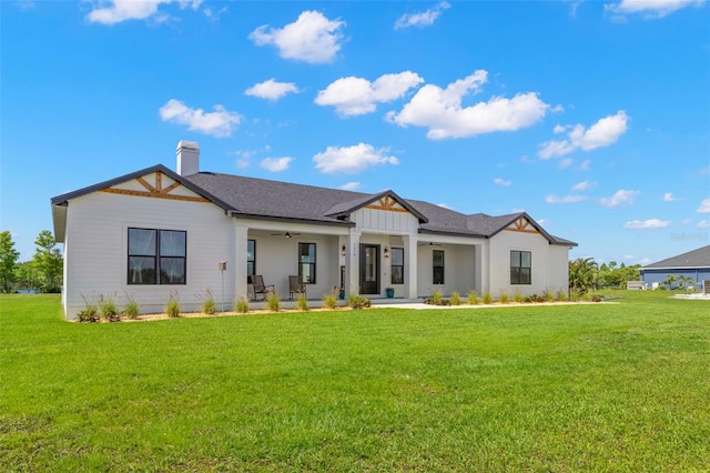 modern inspired farmhouse featuring a ceiling fan, a front lawn, a chimney, and a porch