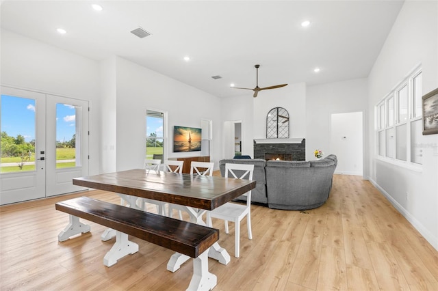 dining space featuring ceiling fan, a fireplace, recessed lighting, and light wood-style floors