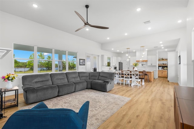 living area featuring plenty of natural light, a ceiling fan, recessed lighting, and light wood finished floors
