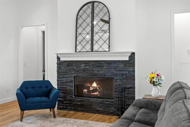 living room featuring wood finished floors, a fireplace, and baseboards