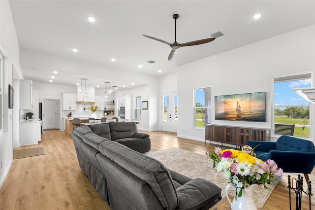 living area with light wood-style flooring, a ceiling fan, recessed lighting, and baseboards