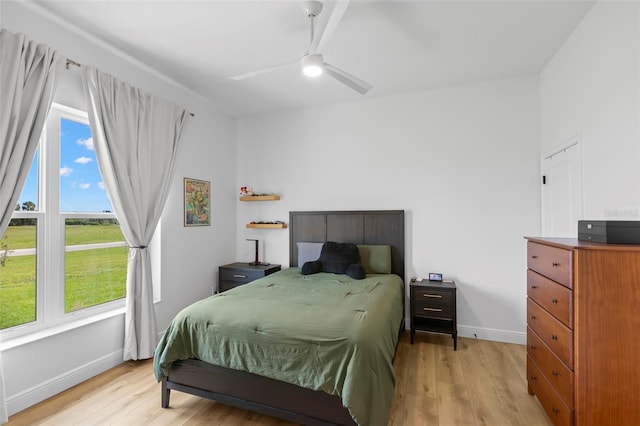 bedroom featuring light wood finished floors, baseboards, and a ceiling fan