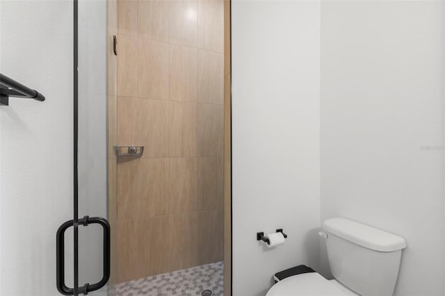bathroom featuring a stall shower and toilet