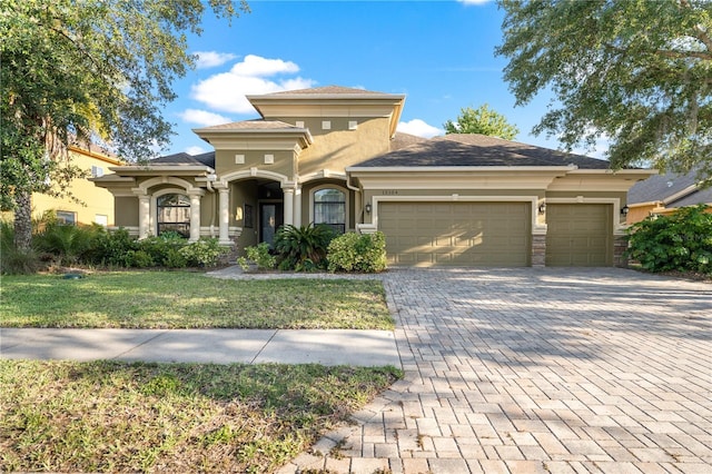 15104 Azra Dr, Odessa, FL 33556 - view of front of house with stucco siding, decorative driveway, an attached garage, and a front lawn