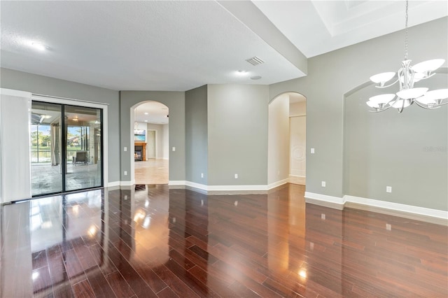 15104 Azra Dr, Odessa, FL 33556 - spare room with wood finished floors, baseboards, a chandelier, and arched walkways