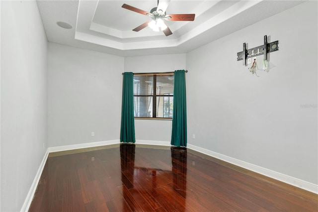 15104 Azra Dr, Odessa, FL 33556 - empty room with a tray ceiling, wood finished floors, a ceiling fan, and baseboards