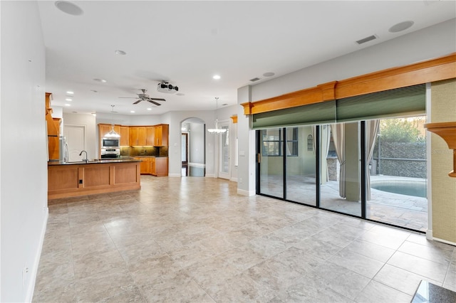 15104 Azra Dr, Odessa, FL 33556 - unfurnished living room featuring baseboards, arched walkways, recessed lighting, a ceiling fan, and a chandelier