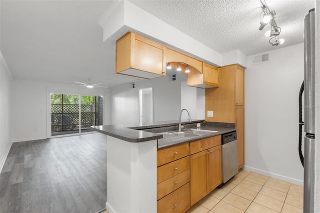 2500 Winding Creek Blvd Unit A104, Clearwater, FL 33761 - kitchen with stainless steel appliances, a sink, a ceiling fan, a peninsula, and a textured ceiling