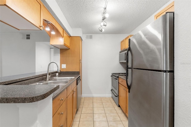2500 Winding Creek Blvd Unit A104, Clearwater, FL 33761 - kitchen featuring appliances with stainless steel finishes, a sink, dark countertops, a textured ceiling, and light tile patterned floors