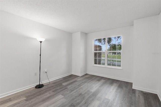 2500 Winding Creek Blvd Unit A104, Clearwater, FL 33761 - spare room featuring wood finished floors, a textured ceiling, and baseboards