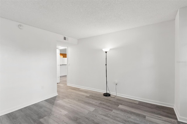 2500 Winding Creek Blvd Unit A104, Clearwater, FL 33761 - empty room featuring wood finished floors, a textured ceiling, baseboards, and a smoke detector