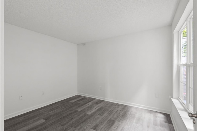 2500 Winding Creek Blvd Unit A104, Clearwater, FL 33761 - empty room with dark wood-style floors, a textured ceiling, and baseboards