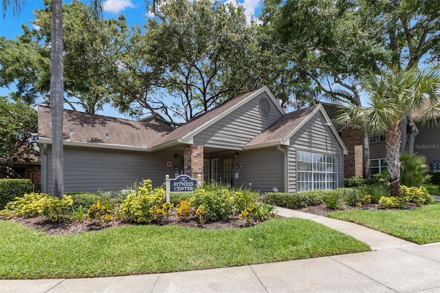 2500 Winding Creek Blvd Unit A104, Clearwater, FL 33761 - ranch-style home featuring a front yard and a shingled roof