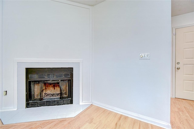 4911 Country Aire Ln, Tampa, FL 33624 - detailed view of wood finished floors, a tiled fireplace, and baseboards