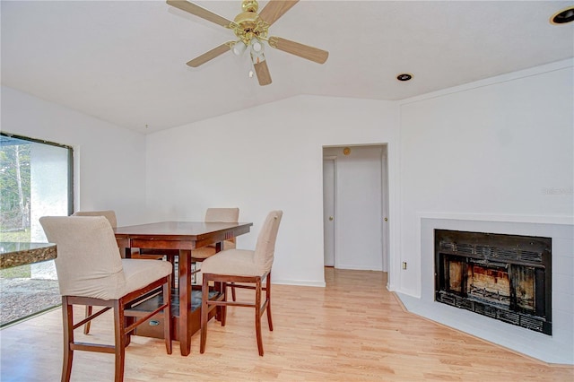4911 Country Aire Ln, Tampa, FL 33624 - dining area with light wood-type flooring, lofted ceiling, ceiling fan, a fireplace, and baseboards