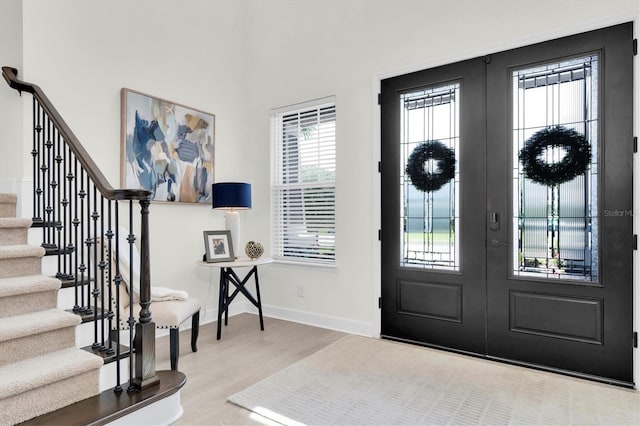 3850 Bonfire Dr, Odessa, FL 33556 - foyer featuring stairway, wood finished floors, baseboards, and french doors
